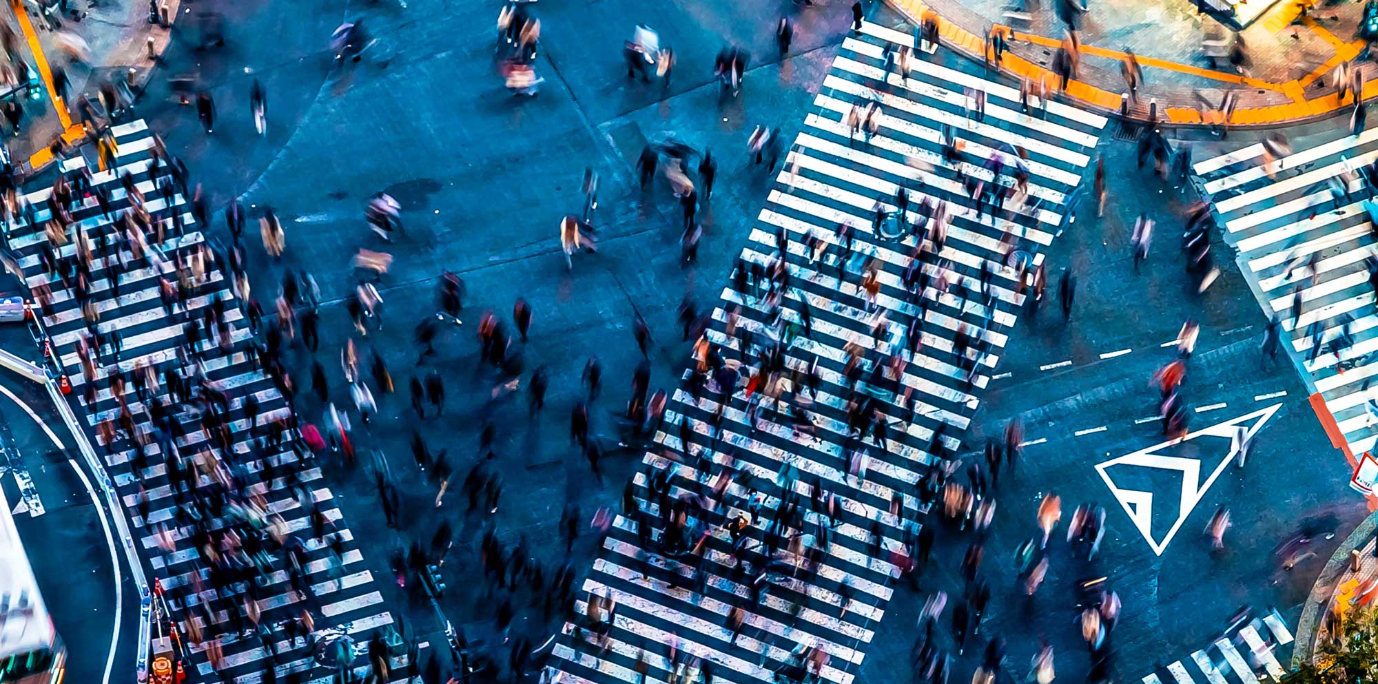 arial view of people crossing a busy intersection